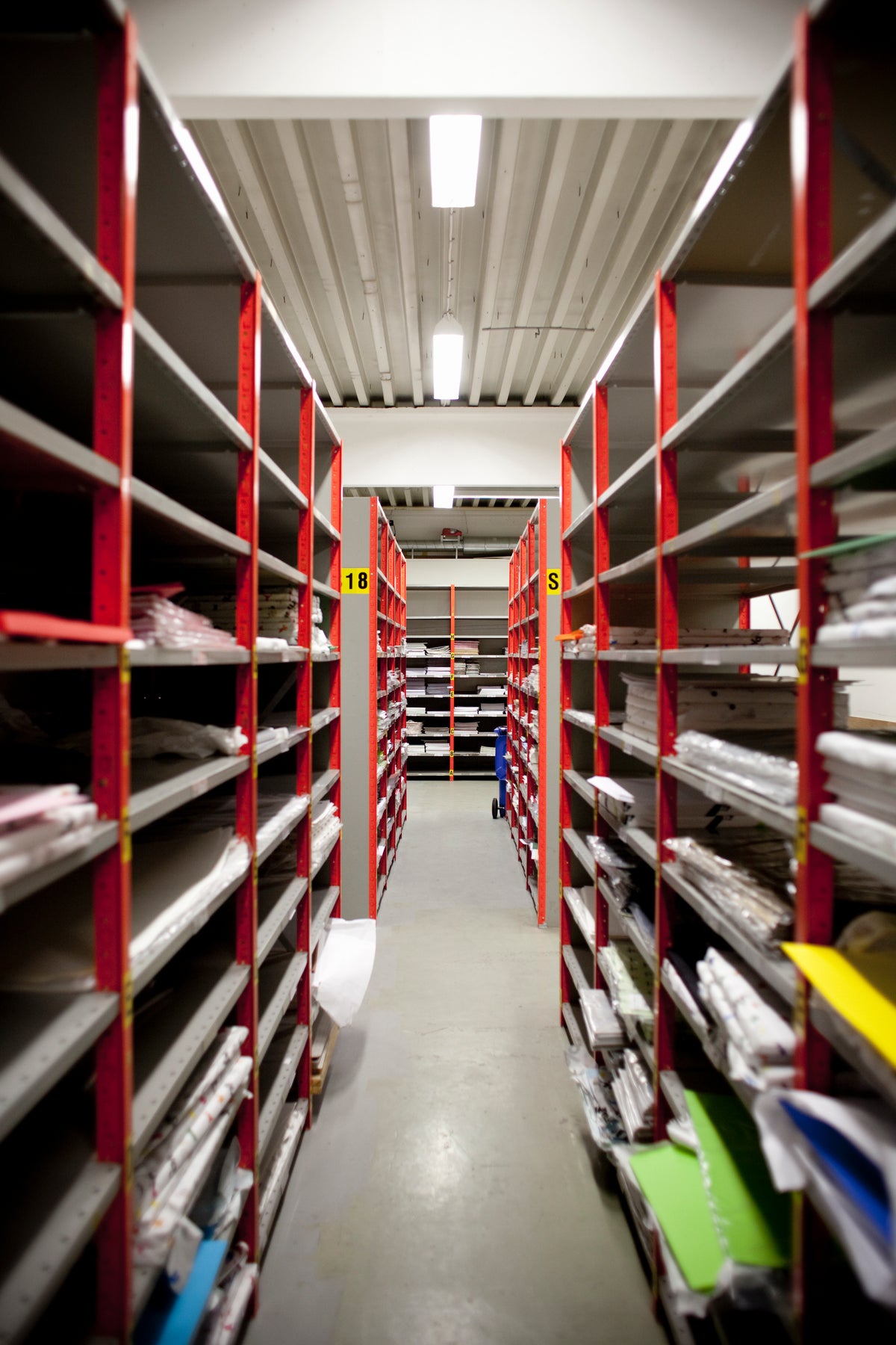 Aisle in warehouse with racks full of materials